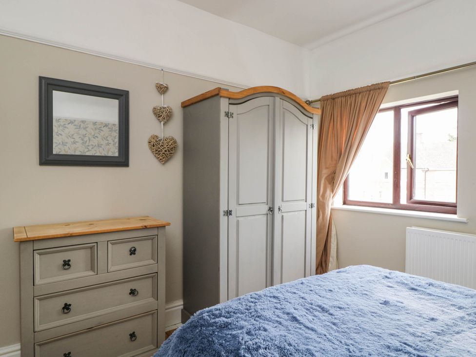 A bedroom with a wardrobe, mirror, and chest of drawers at 1 Stanway Road
