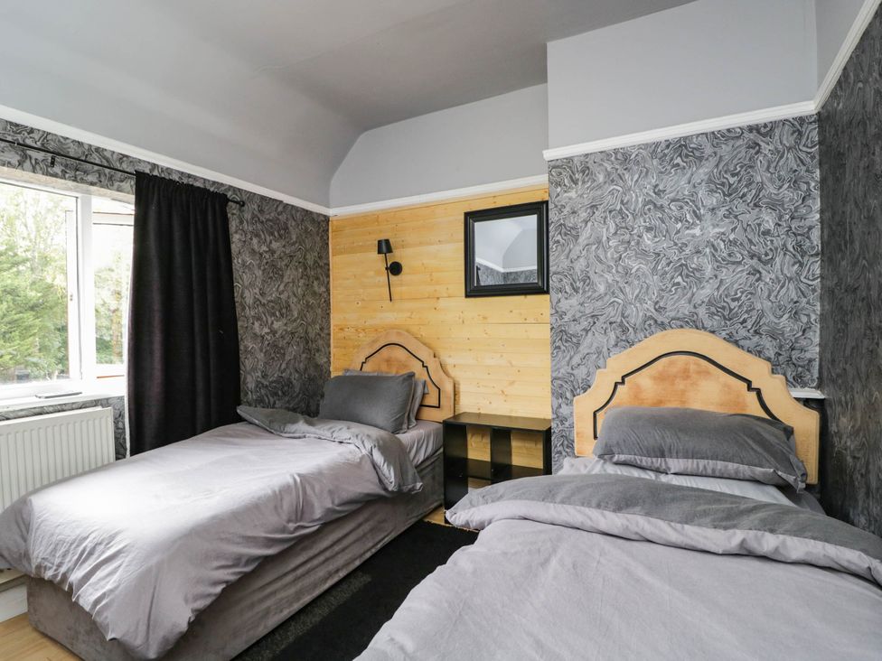 A bedroom with twin beds and a mirror at 1 Stanway Road