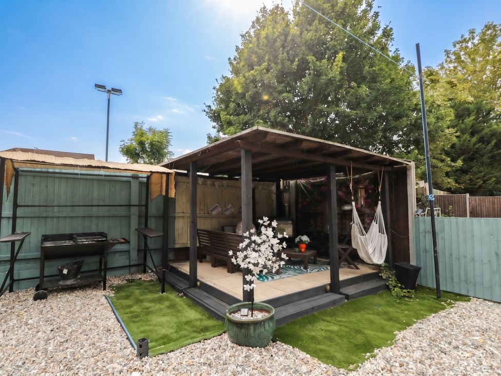 An outdoor structure with a grill and seating area at 1 Stanway Road