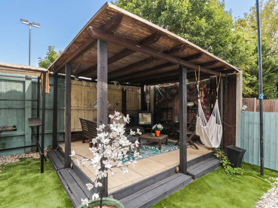 A garden shelter with a hammock and seating area at 1 Stanway Road