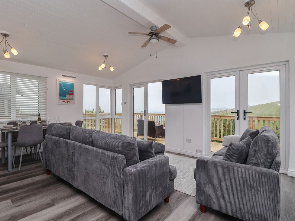 A living room with a sofa and dining table at Lodge 19 in Torpoint
