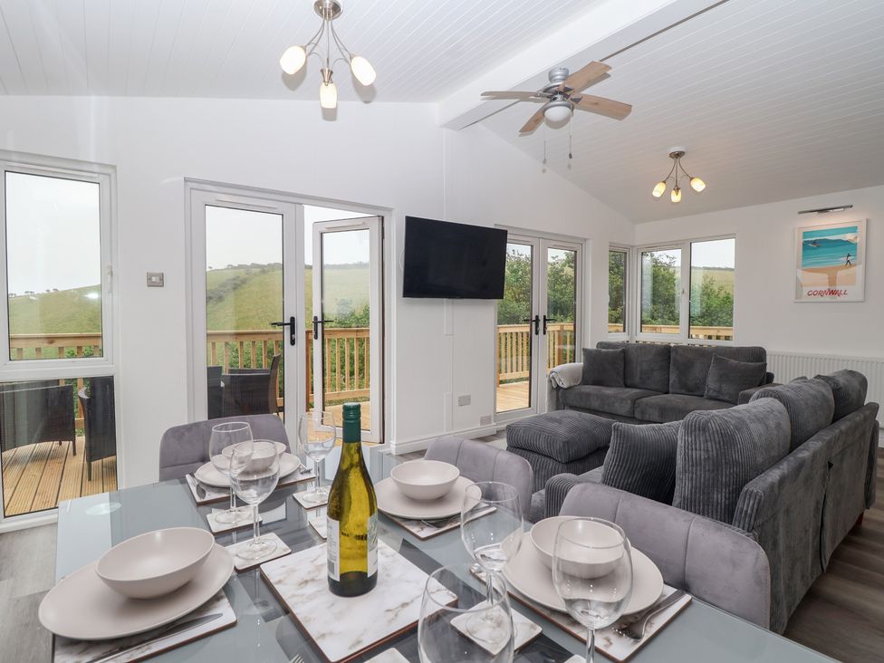 A living room with a dining table and a couch at Lodge 19 in Torpoint