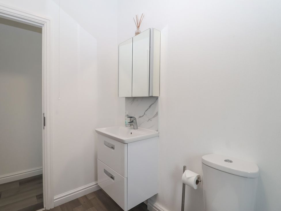 A bathroom with sink, toilet and storage at Lodge 19 in Torpoint