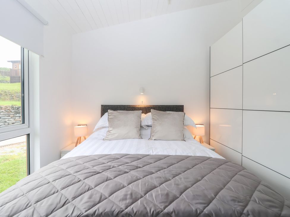 A bedroom with a bed and lamps at Lodge 19 in Torpoint