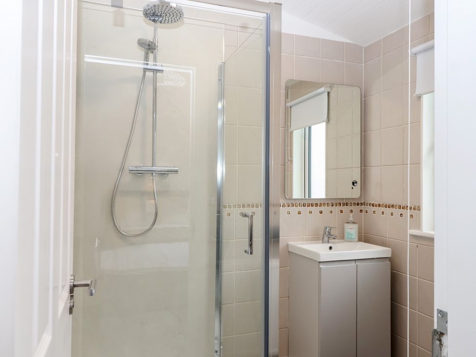 A bathroom with a shower and sink at Lodge 19 in Torpoint