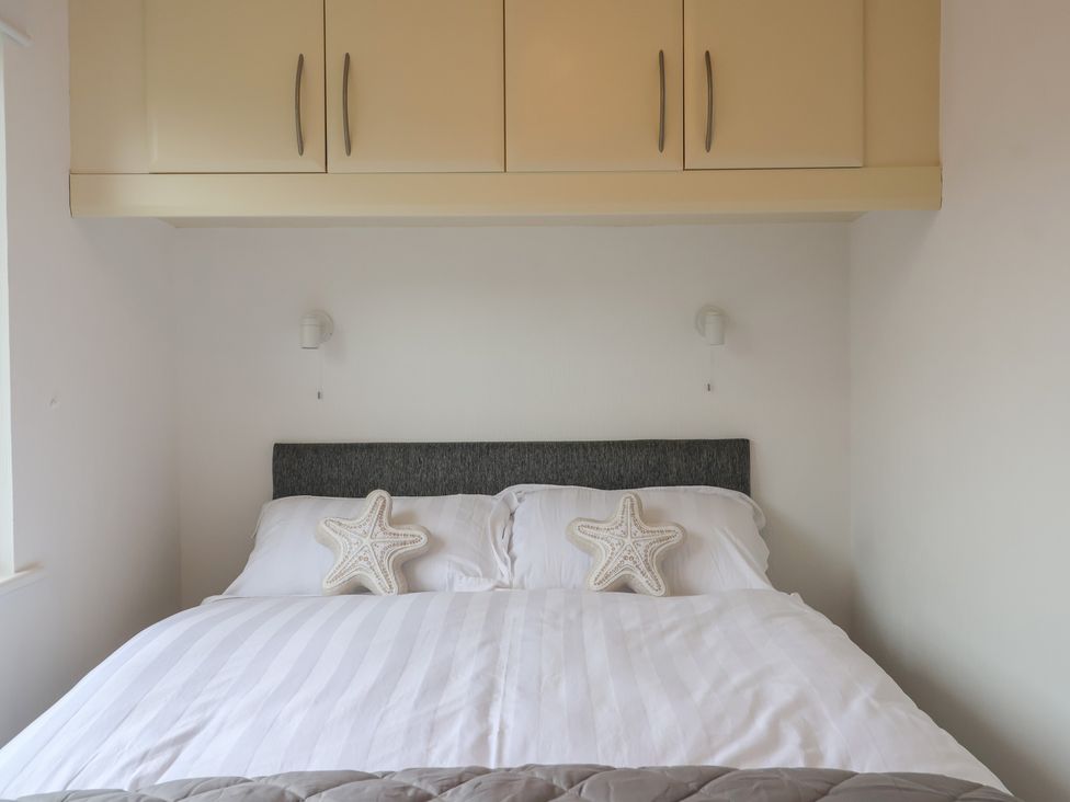 A bedroom with a bed and wall cabinet at Lodge 19 in Torpoint