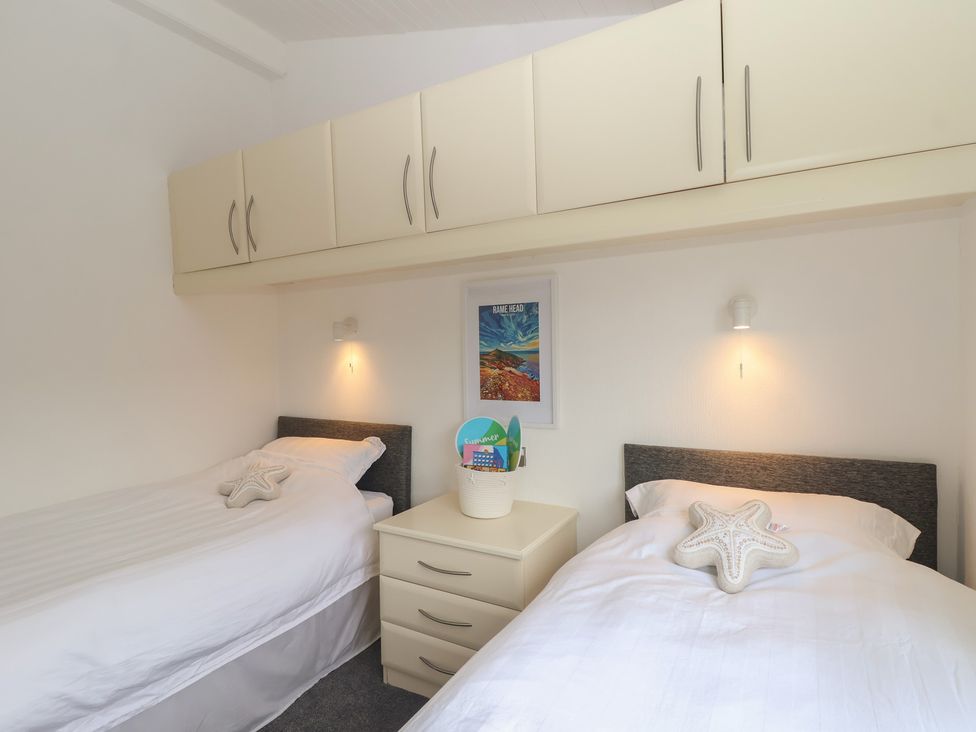 A bedroom with two beds and a dresser at Lodge 19 in Torpoint