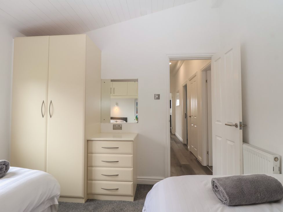 A bedroom with a wardrobe and chest of drawers at Lodge 19 in Torpoint