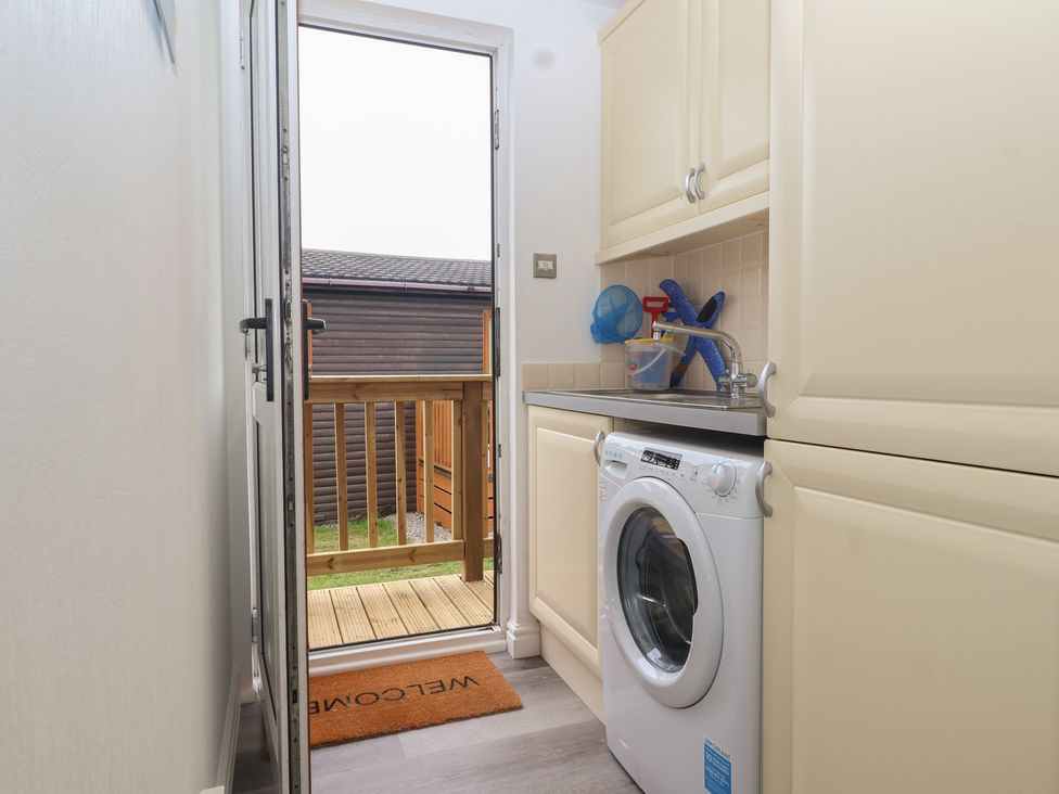 A utility room with a washing machine and sink at Lodge 19 in Torpoint
