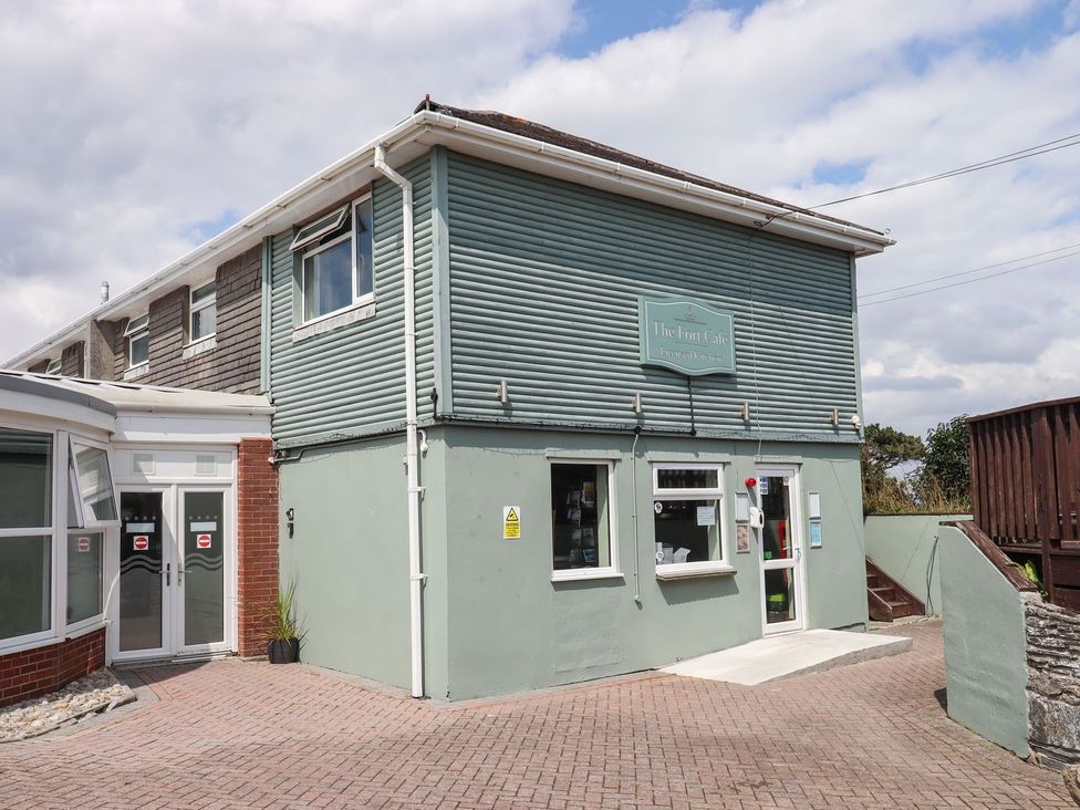 A cafe building with a sign and windows at Lodge 19 in Torpoint