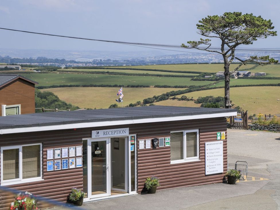 A reception building with a view of fields and a tree at Lodge 19 Torpoint