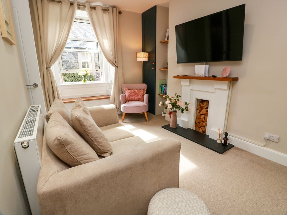 A living room with a sofa and television at 19 Biggiesknowe in Peebles