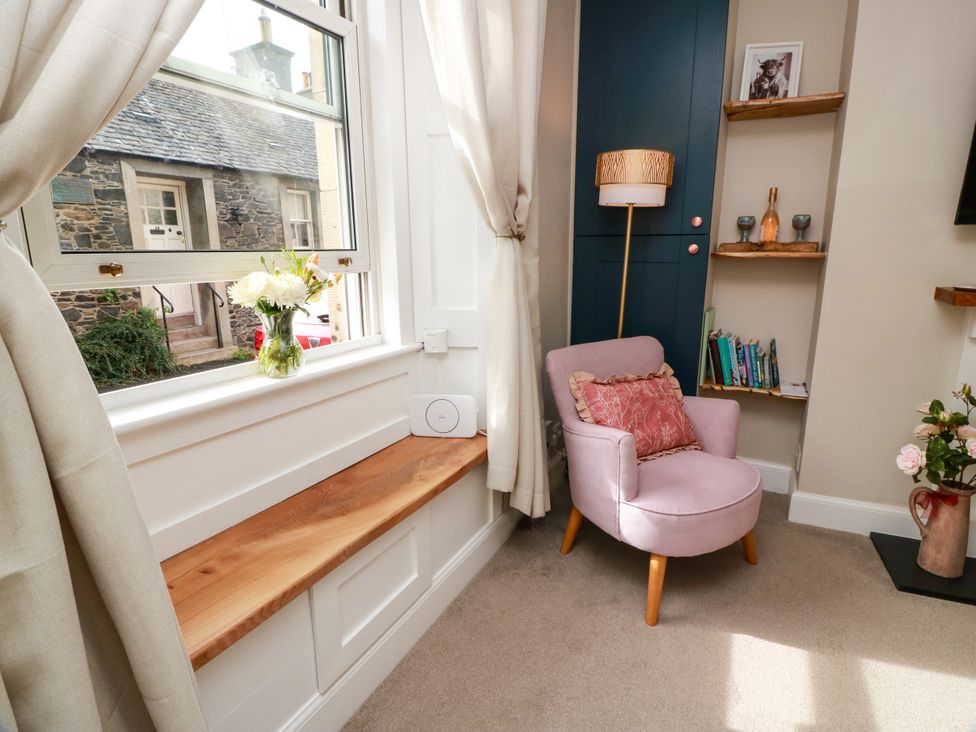 A snug with a chair, flower vase and shelf at 19 Biggiesknowe in Peebles