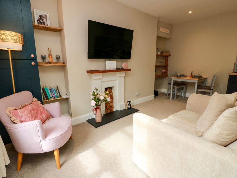 A living room with a television and fireplace at 19 Biggiesknowe in Peebles