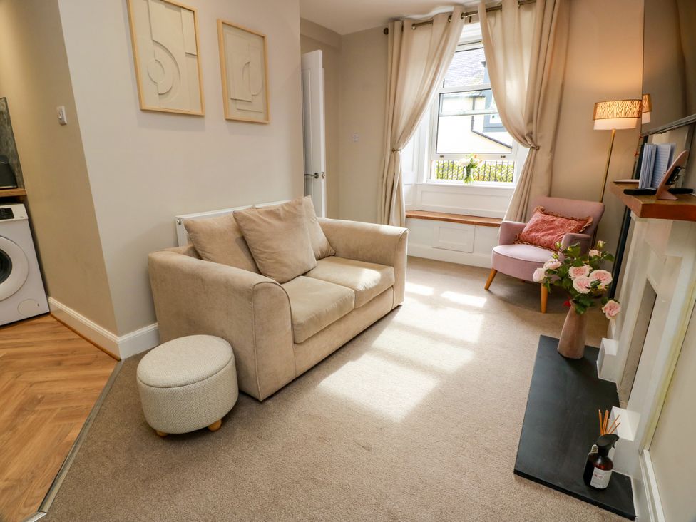 A living room with a sofa and armchair at 19 Biggiesknowe Peebles