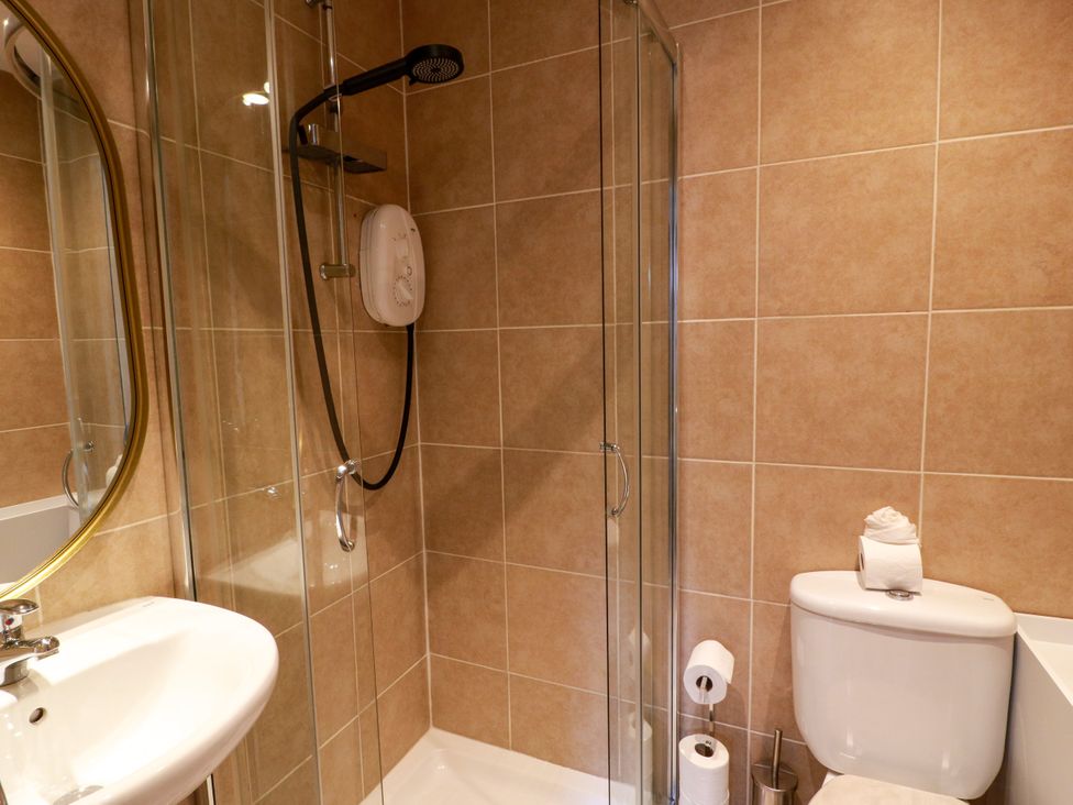 A bathroom with a shower, toilet, and sink at 19 Biggiesknowe Peebles