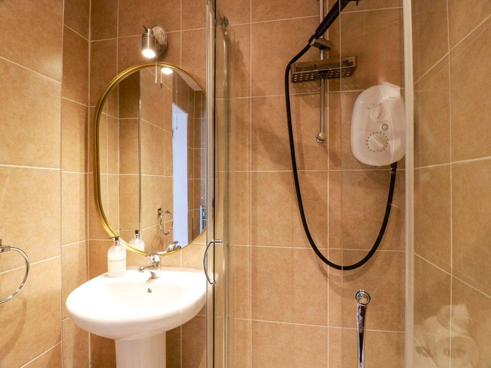 A bathroom with a shower and washbasin at 19 Biggiesknowe in Peebles