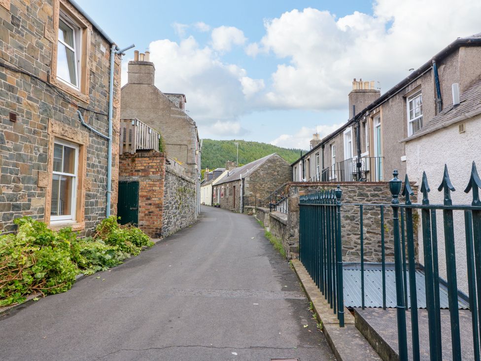 A street view with stone buildings and a gravel road at 19 Biggiesknowe Peebles