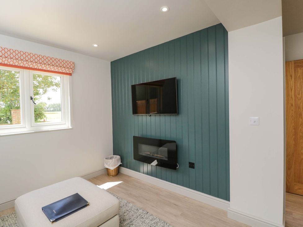 A living room with a television and electric fireplace at Poppy Patch in Stratton Audley near Bicester