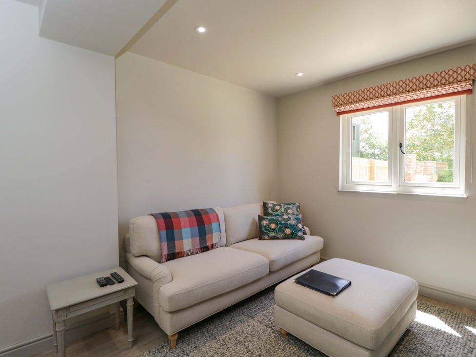 A living room with a sofa and window at Poppy Patch in Stratton Audley near Bicester