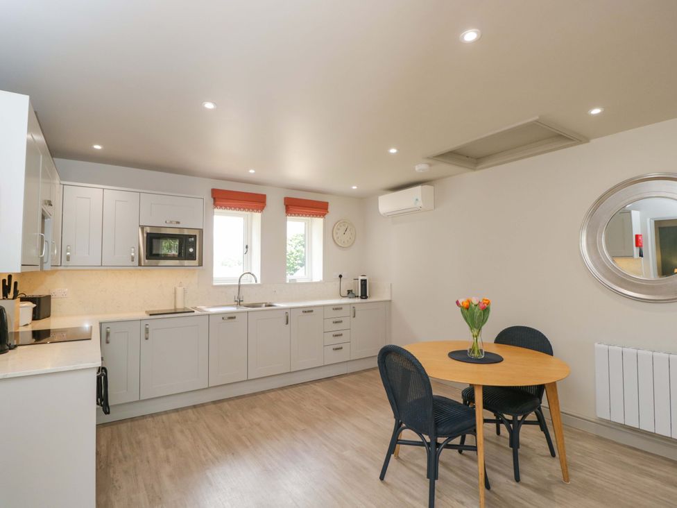 A kitchen with a dining table and chairs at Poppy Patch in Stratton Audley near Bicester