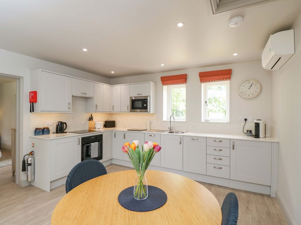 A kitchen with modern appliances and a dining table at Poppy Patch in Stratton Audley near Bicester