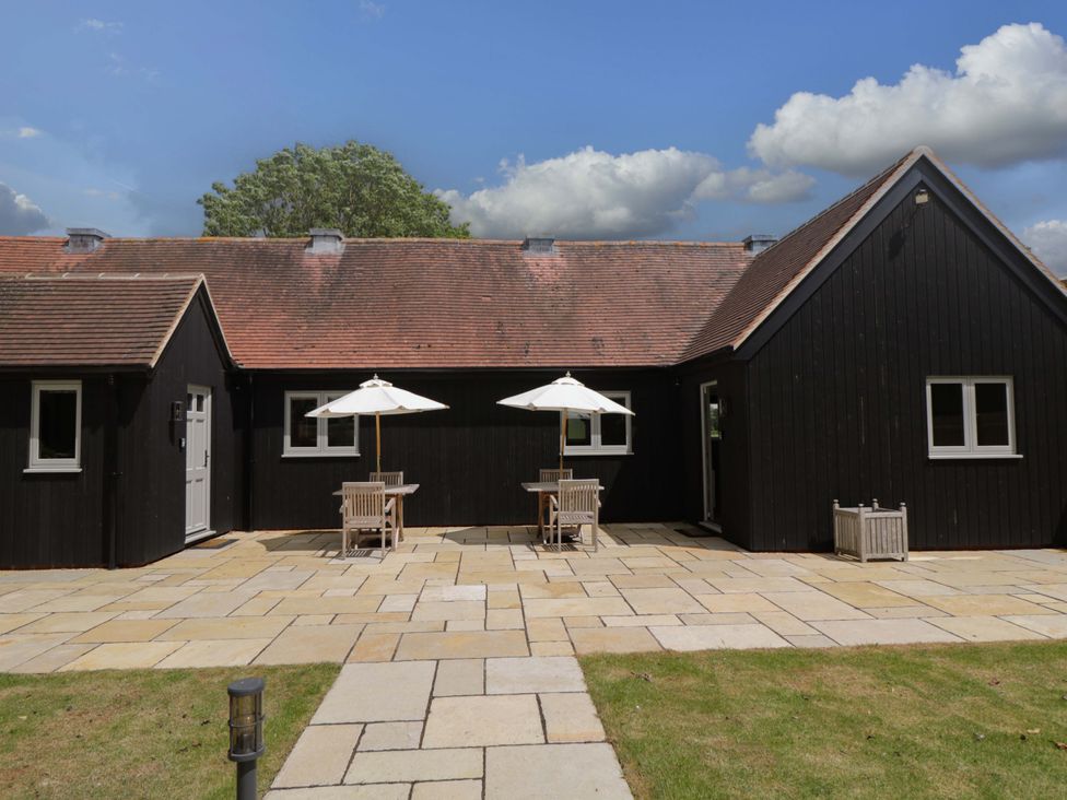 A house with patio furniture and umbrellas at Poppy Patch in Stratton Audley near Bicester