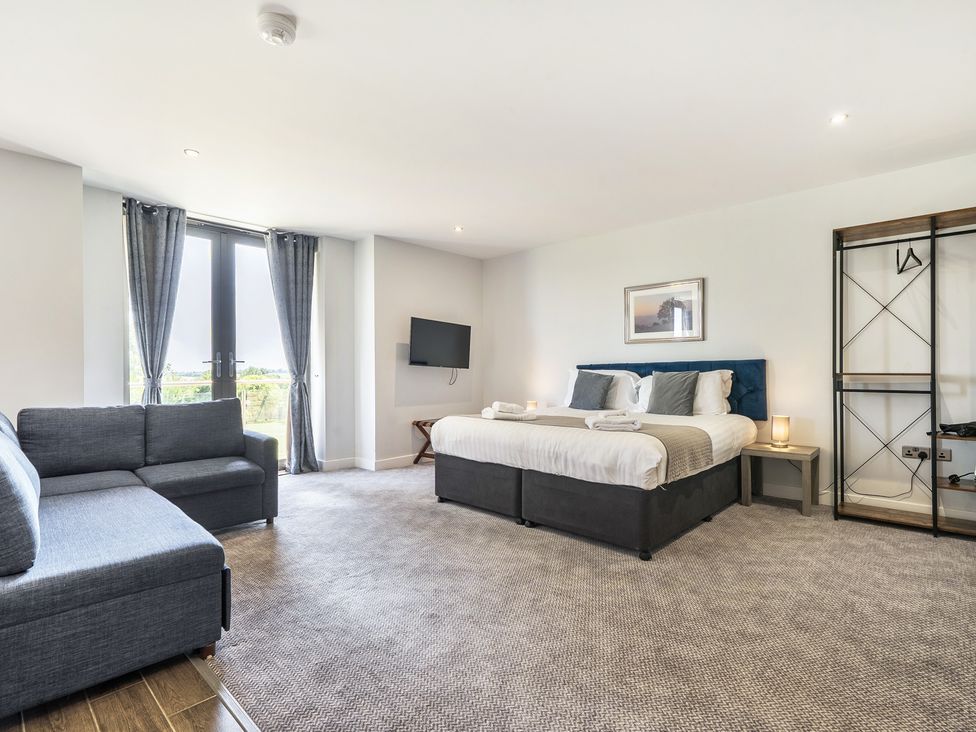 A bedroom with a bed and sofa at Cotswolds Apartment, sleeps 4, Chipping Norton