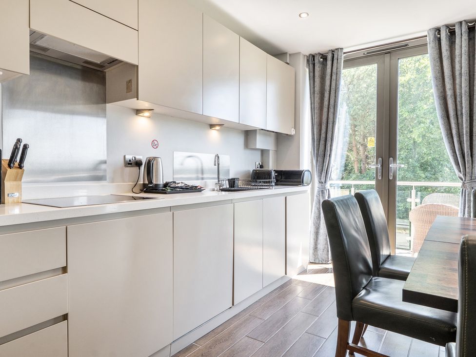 A kitchen with modern appliances and seating at Cotswolds Apartments 2B/S4 in Chipping Norton