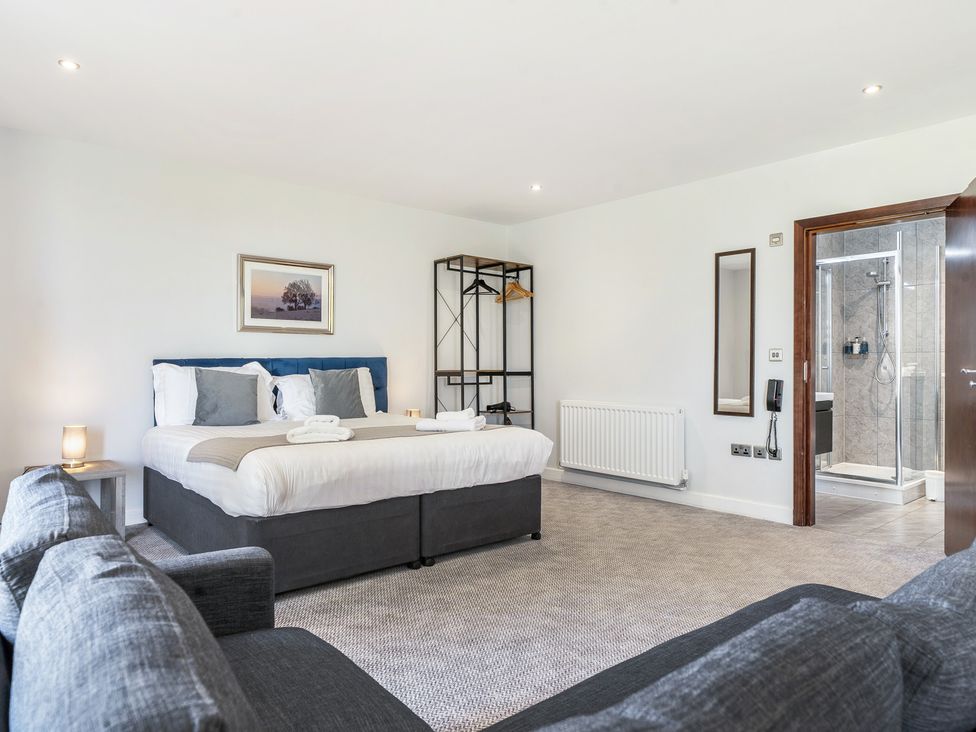 A bedroom with a bed and shower area at Cotswolds Apartments 2B/S4 in Chipping Norton