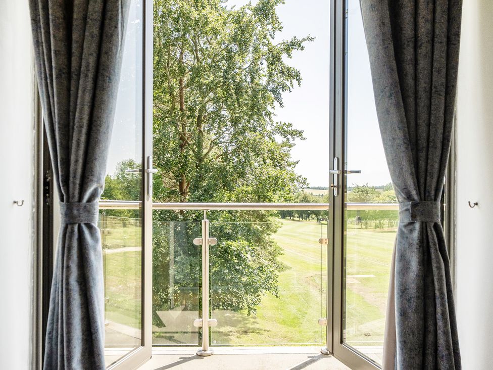 A balcony with glass doors and a view of trees at Cotswolds Apartments 2B/S4 in Chipping Norton