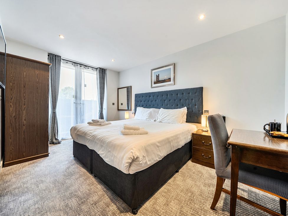 A bedroom with a bed and desk at Cotswolds Apartments 2B/S4 Chipping Norton