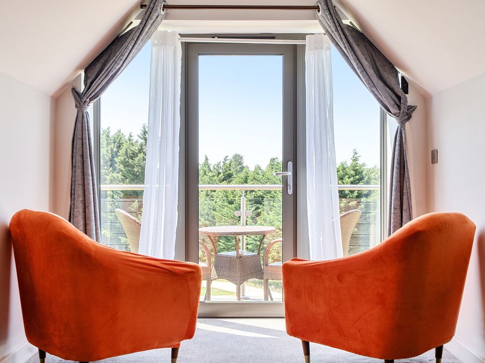 A snug area with two armchairs and a balcony view at Cotswolds Apartments 4B/S8 in Chipping Norton