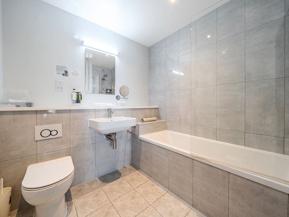 A bathroom with a sink, toilet, bathtub, and shower area at Cotswolds Apartments 4B/S8 in Chipping Norton