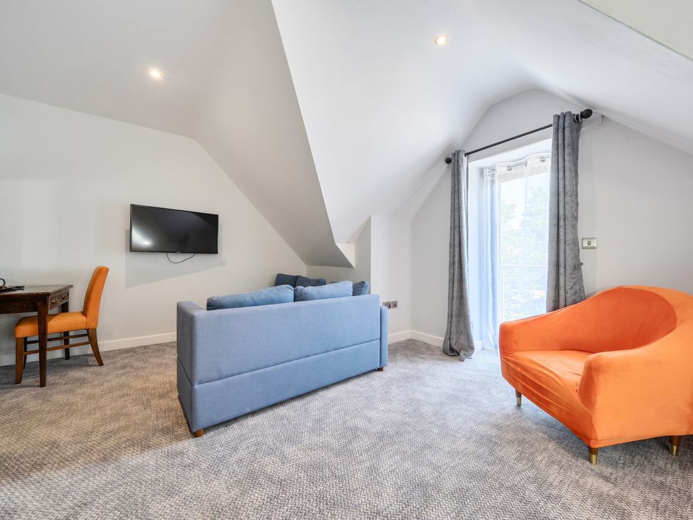 A living room with a sofa and television at Cotswolds Apartments 4B/S8 in Chipping Norton