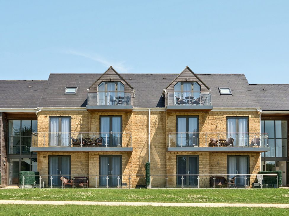 A building exterior with balconies and glass railings at Cotswolds Apartments 4B/S8 in Chipping Norton