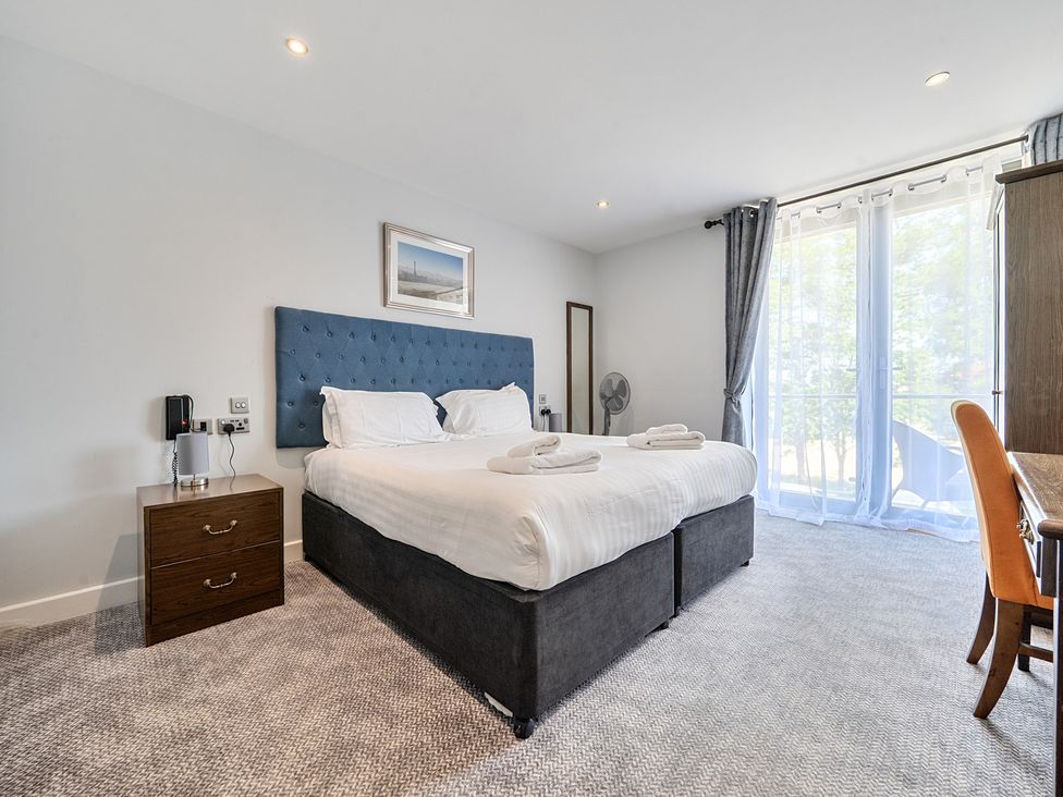 A bedroom with a bed and nightstand at Cotswolds Apartments 4B/S8 in Chipping Norton