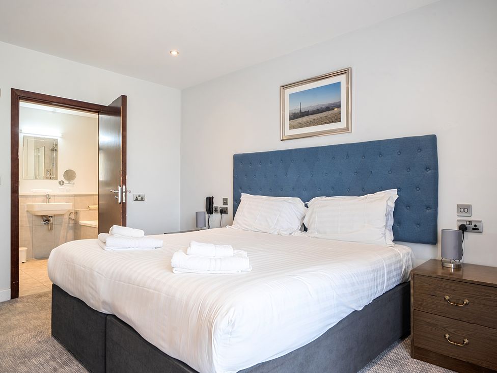 A bedroom with a double bed and attached bathroom at Cotswolds Apartments 4B/S8, Chipping Norton
