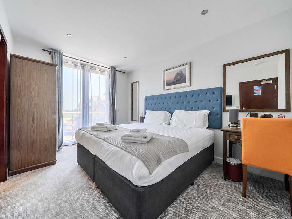 A bedroom with a bed and wardrobe at Cotswolds Apartments 4B/S8 in Chipping Norton