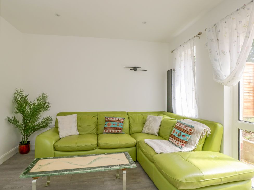 A living room with a green sofa and a table at 167 Leybourne Avenue Bournemouth