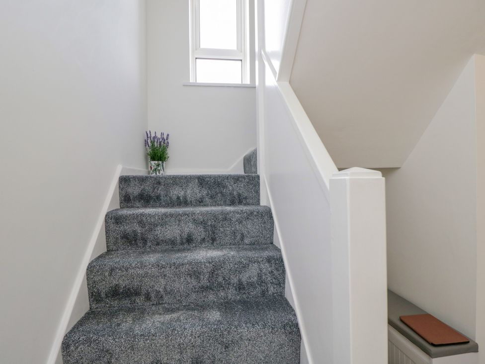 A staircase with a window and a flower vase at 167 Leybourne Avenue Bournemouth