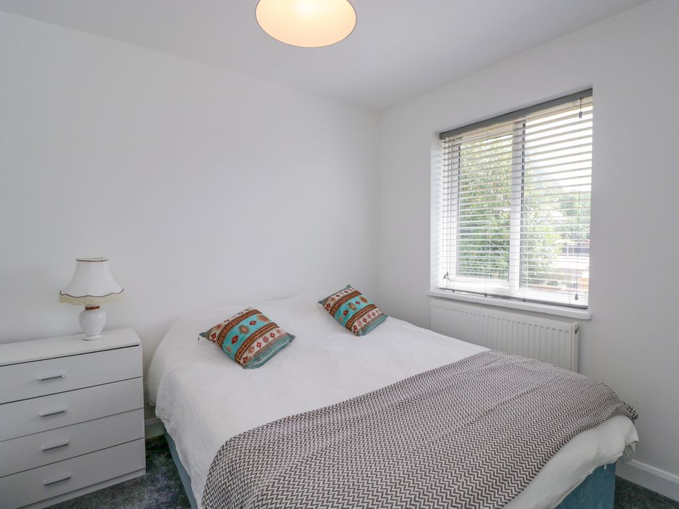 A bedroom with a double bed and bedside lamp at 167 Leybourne Avenue in Bournemouth