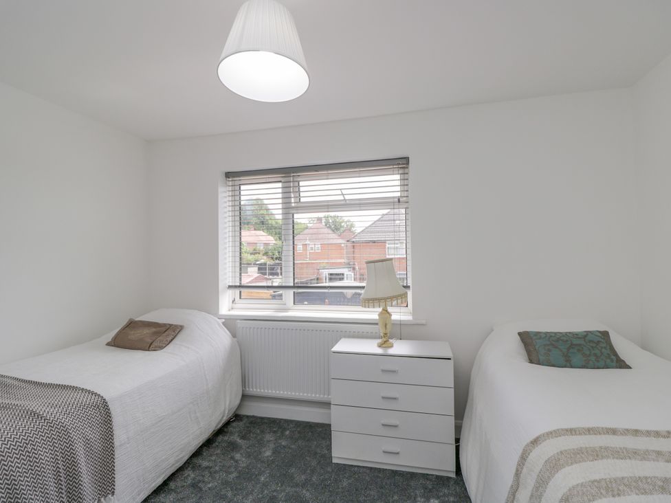 A bedroom with two beds and a chest of drawers at 167 Leybourne Avenue in Bournemouth