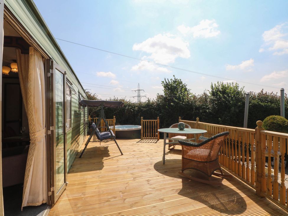 An outdoor area with a hot tub and seating at Buzzards Retreat in Wrexham