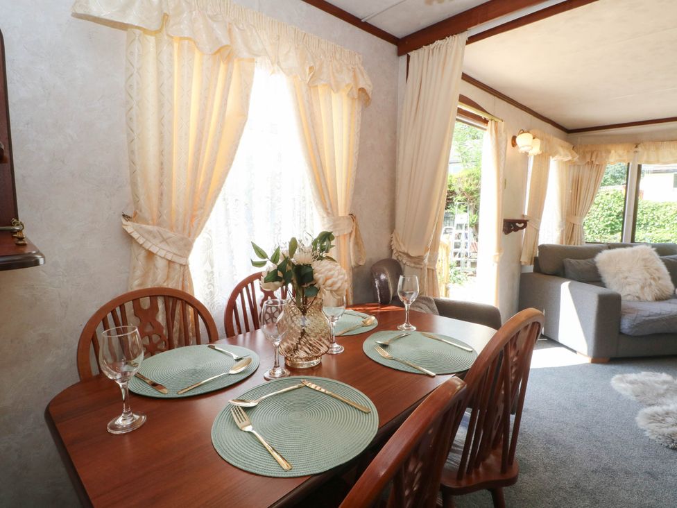 A dining room with a table set for four at Buzzards Retreat in Wrexham