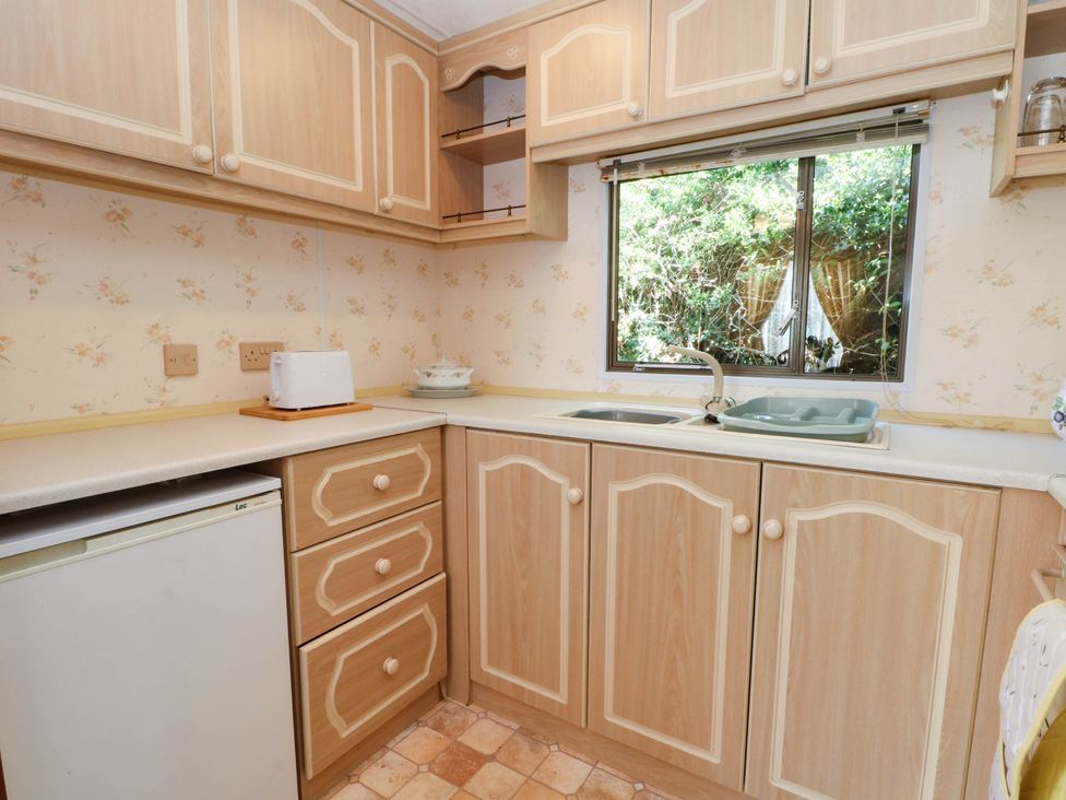 A kitchen with cabinets, sink, and toaster at Buzzards Retreat in Wrexham