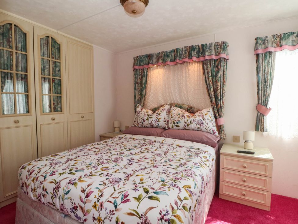 A bedroom with a bed and wardrobe at Buzzards Retreat in Wrexham