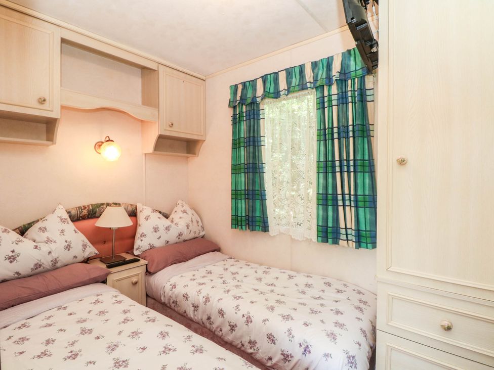 A bedroom with two beds and a wardrobe at Buzzards Retreat in Wrexham