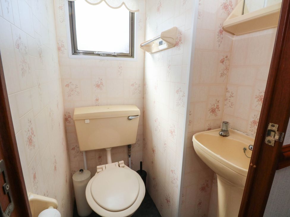 A bathroom with a toilet and sink at Buzzards Retreat in Wrexham