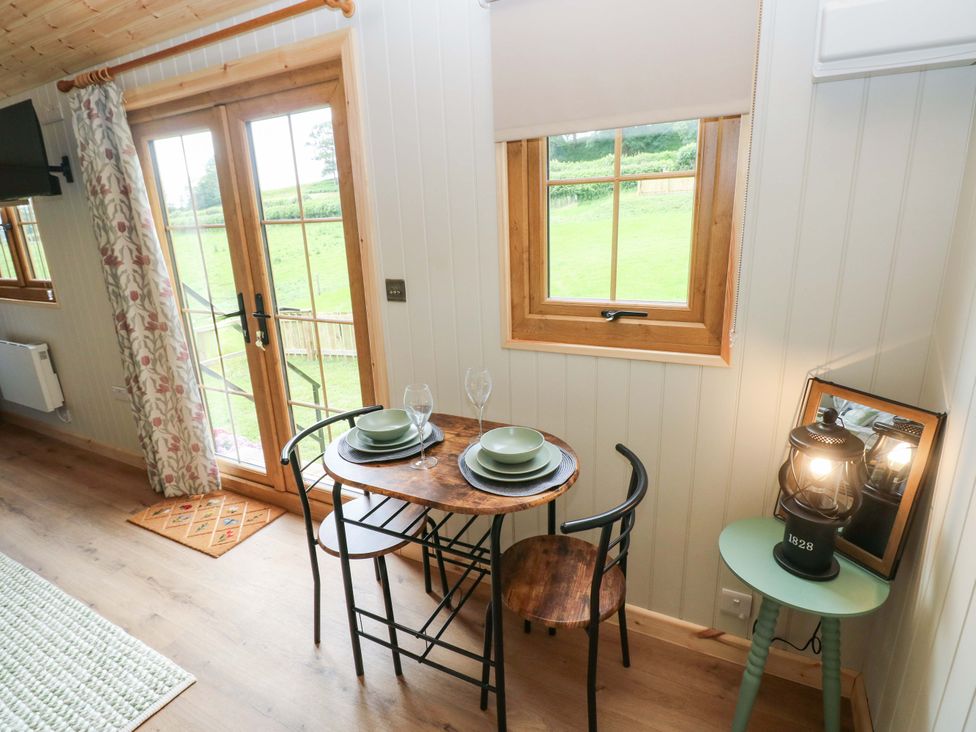 A dining area with a table and chairs at Shepherd Hut 1 in Llandeilo